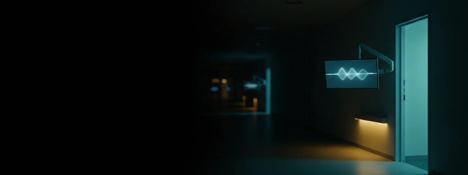 A darkened clinical corridor with one lit doorway and a wall-mounted monitor carrying a soft glowing waveform.