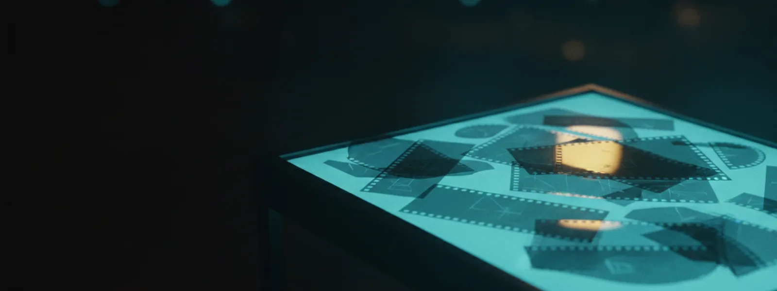 Translucent film sheets of different sizes overlapping at loose angles on a glowing dark light-table.